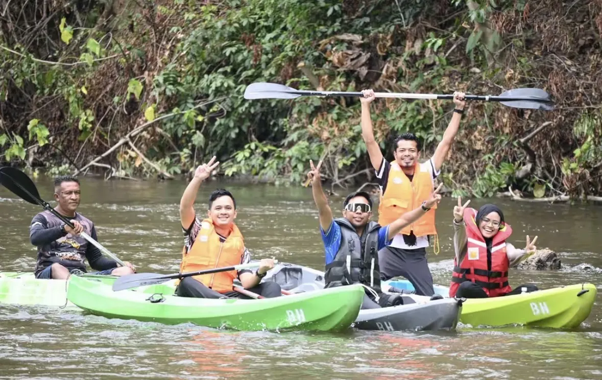 Sekumpulan tetamu berkayak dan bersorak di sungai